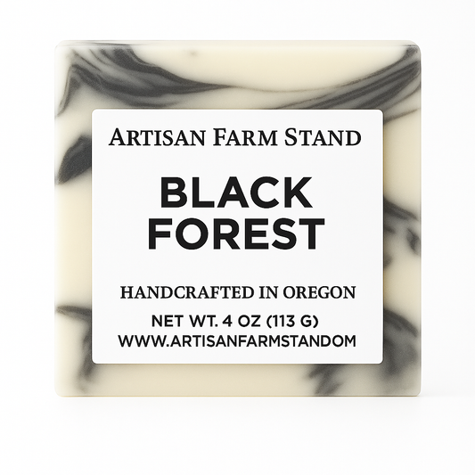 Bar of soap with a label reading 'Artisan Farm Stand Black Forest' on a white background