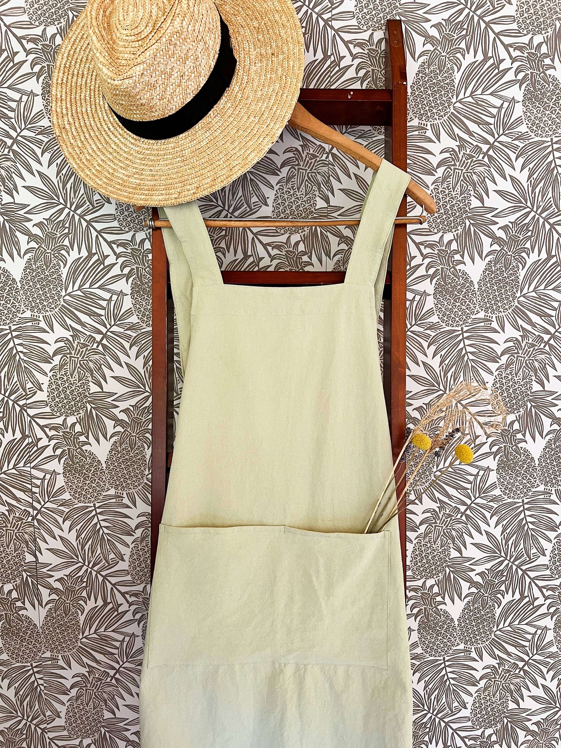 Handmade cross-back apron with deep pockets, durable fabric, and a comfortable fit for kitchen, gardening, or crafting