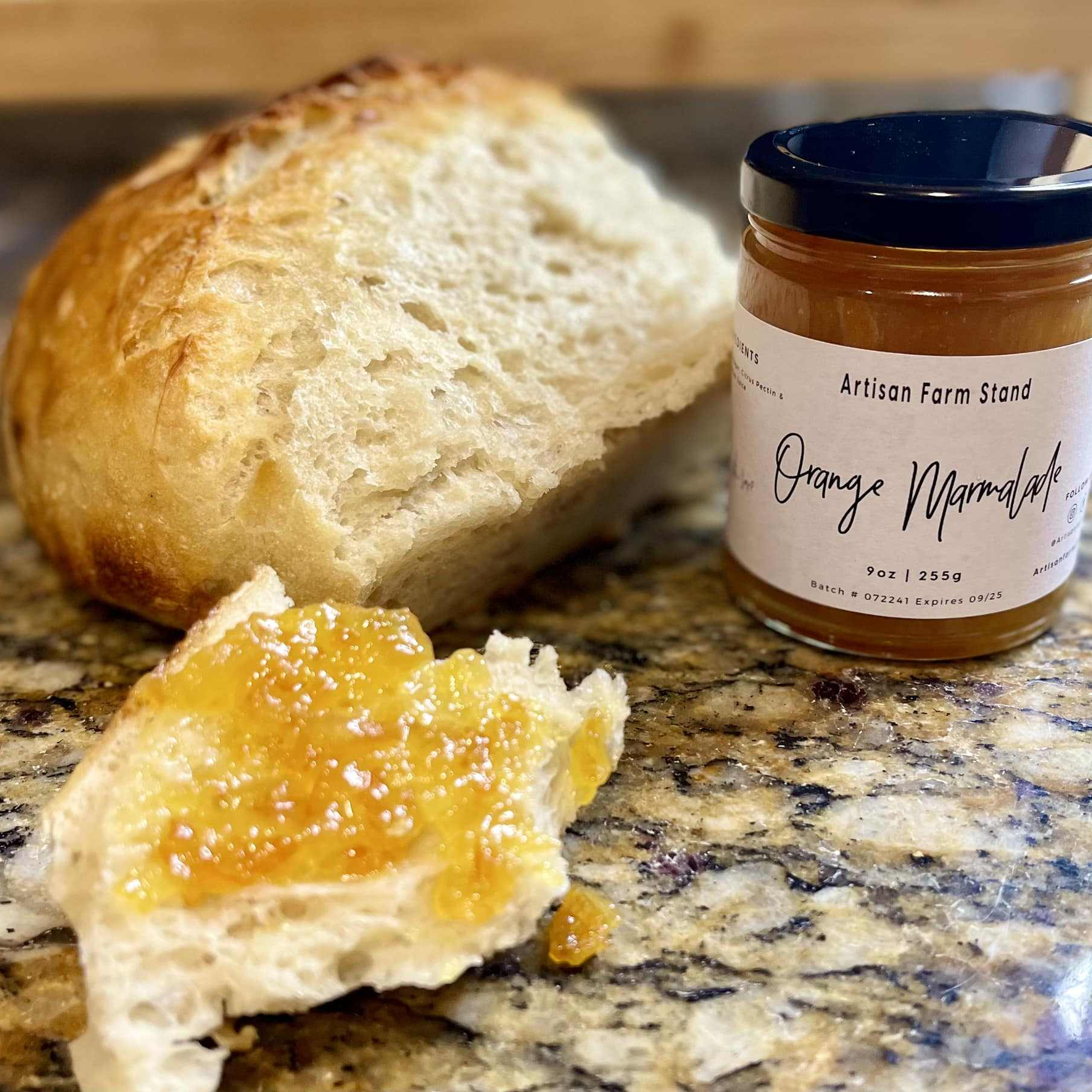 Artisan Farmstand's Orange Marmalade jar with bread spread, showcasing handcrafted citrus preserve.